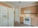 Well-equipped kitchen featuring white appliances, light wood cabinets, and tile flooring for a clean and modern look at 10722 W Irma Ln, Peoria, AZ 85373
