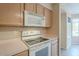 Bright kitchen featuring white appliances, light wood cabinets, tile flooring and a view to the breakfast nook at 10722 W Irma Ln, Peoria, AZ 85373