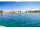 Scenic view of the community lake, reflecting bright sky, and surrounding houses at 10722 W Irma Ln, Peoria, AZ 85373