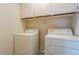 Functional laundry room with a side-by-side washer and dryer set and cabinetry above for storage at 10722 W Irma Ln, Peoria, AZ 85373