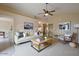 Cozy living room featuring neutral furniture, modern decor, a ceiling fan, and an open floor plan at 10722 W Irma Ln, Peoria, AZ 85373