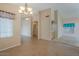 Spacious living room with tile floors, neutral paint, chandelier, and multiple entry ways at 10722 W Irma Ln, Peoria, AZ 85373