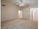 Large primary bedroom with neutral carpet, walk-in closet, ceiling fan and ensuite bathroom at 10722 W Irma Ln, Peoria, AZ 85373