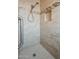 Stylishly renovated shower features decorative tile accents, grab bars, and a built-in niche at 10722 W Irma Ln, Peoria, AZ 85373