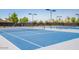 Well-maintained blue tennis courts with lighting for evening play in a gated community at 10722 W Irma Ln, Peoria, AZ 85373