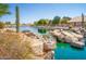Scenic view of a tranquil water feature with natural stone and cascading waterfalls in a lush community at 10722 W Irma Ln, Peoria, AZ 85373