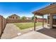 Large grassy backyard with stone perimeter and block fence under a clear blue sky at 11531 E Persimmon Ave, Mesa, AZ 85212