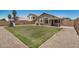 Spacious grassy backyard with a stone perimeter, play structure and block fence providing privacy at 11531 E Persimmon Ave, Mesa, AZ 85212