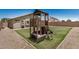 Backyard featuring a custom playset, grass, stone perimeter and a block fence for privacy at 11531 E Persimmon Ave, Mesa, AZ 85212