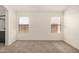 Spacious, neutral bedroom with carpet and two windows for ample natural light and a relaxing atmosphere at 11531 E Persimmon Ave, Mesa, AZ 85212