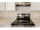 Modern kitchen featuring a smooth cooktop, white cabinets, and sleek countertops for a stylish cooking experience at 11531 E Persimmon Ave, Mesa, AZ 85212