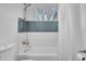 Bathroom featuring a shower-over-tub with blue and white tiles and a window at 1233 E El Camino Dr, Phoenix, AZ 85020