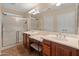 Bright bathroom features a double sink vanity, large mirror, and walk-in shower at 12712 W Milton Dr, Peoria, AZ 85383