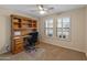Bedroom features a built in desk, ceiling fan, and a large window for natural light at 12712 W Milton Dr, Peoria, AZ 85383