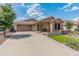 Charming single-story home featuring a stone facade, covered porch, and well-manicured landscaping on a sunny day at 12712 W Milton Dr, Peoria, AZ 85383