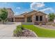 Inviting single-Gathering home with stone detailing, green grass, and a three-car garage at 12712 W Milton Dr, Peoria, AZ 85383