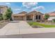 Charming single-story home featuring a well-manicured yard, stone accents, and a two-car garage at 12712 W Milton Dr, Peoria, AZ 85383
