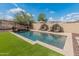 Backyard pool with in-pool lounge chairs, umbrellas, and desert landscaping in a private backyard setting at 12712 W Milton Dr, Peoria, AZ 85383