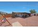 Spacious backyard with gravel, covered patio, playset, and partial fencing, great for outdoor enjoyment at 12810 N 20Th St, Phoenix, AZ 85022
