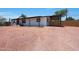 Home exterior featuring a covered entrance, carport, gravel yard, and a bright red front door at 12810 N 20Th St, Phoenix, AZ 85022