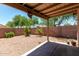 Private backyard featuring a covered patio, desert landscaping, and block wall fencing at 13861 W Elm St, Surprise, AZ 85374