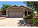 Charming single-story home featuring a two-car garage and desert landscaping at 13861 W Elm St, Surprise, AZ 85374