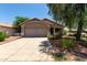 Charming single-story home featuring a two-car garage and desert landscaping at 13861 W Elm St, Surprise, AZ 85374