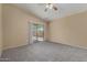 Living room featuring neutral carpet, vaulted ceiling, and sliding glass door to backyard at 13861 W Elm St, Surprise, AZ 85374