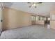Spacious living room featuring neutral carpet, ceiling fan, and bright natural light at 13861 W Elm St, Surprise, AZ 85374