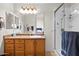 Bathroom features a wood vanity, large mirror, and a glass-enclosed shower stall at 16538 N Oachs Dr, Surprise, AZ 85374