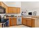 Bright kitchen showcasing wood cabinets, stainless steel appliances, and a sink with backyard view at 16538 N Oachs Dr, Surprise, AZ 85374
