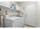 Practical laundry room equipped with a washer, dryer, and additional storage shelving at 16538 N Oachs Dr, Surprise, AZ 85374
