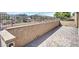 Private backyard patio area with brick pavers, stucco wall, and iron fence offering views of the surrounding landscape at 16881 W Merrell St, Goodyear, AZ 85395
