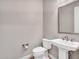 Well-lit powder room features a pedestal sink, framed mirror, and modern fixtures at 16881 W Merrell St, Goodyear, AZ 85395