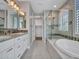 A luxurious bathroom with double vanity, sleek soaking tub, glass shower and neutral tile accents at 16881 W Merrell St, Goodyear, AZ 85395