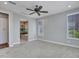 Bright bedroom with carpet floors, a ceiling fan, large window, and access to the luxurious bathroom at 16881 W Merrell St, Goodyear, AZ 85395