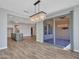 Open-concept dining area with modern light fixture, slider door and view to kitchen at 16881 W Merrell St, Goodyear, AZ 85395