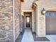 The home features a secure front door, stone accents and a desert style landscape at 16881 W Merrell St, Goodyear, AZ 85395