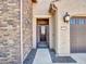The home features a secure front door, stone accents and a desert style landscape at 16881 W Merrell St, Goodyear, AZ 85395