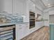 Bright open kitchen with white cabinets, stainless appliances, a wine cooler, and pull out storage at 16881 W Merrell St, Goodyear, AZ 85395