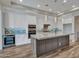 Modern kitchen boasts a large granite island, stainless appliances, and pendant lighting at 16881 W Merrell St, Goodyear, AZ 85395