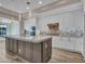 Modern kitchen features a large island, stainless steel appliances, white cabinets, and stylish lighting at 16881 W Merrell St, Goodyear, AZ 85395