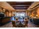 Elegant lounge area features a wooden bar, beamed ceilings, hardwood floors, and comfortable seating at 16881 W Merrell St, Goodyear, AZ 85395