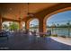 Covered outdoor seating area with multiple tables and chairs overlooking the tennis courts at 16881 W Merrell St, Goodyear, AZ 85395