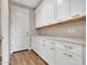 A bright pantry with white cabinets and drawers, with wooden slide-out shelves for maximum storage at 16881 W Merrell St, Goodyear, AZ 85395