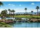 Scenic pond with lush greenery and trees in the PebbleCreek Model Home Village community at 16881 W Merrell St, Goodyear, AZ 85395