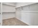 Neutral carpet flooring in walk-in closet with shelving for added storage and organization at 16881 W Merrell St, Goodyear, AZ 85395