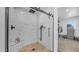 Modern bathroom with glass enclosed shower, marble tile walls, and wood look tile flooring at 1717 W Roma Ave, Phoenix, AZ 85015