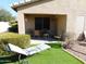 Outdoor space with an artificial lawn, chair, covered patio, and well-kept shrubs at 20282 N 104Th Ave, Peoria, AZ 85382