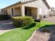 Home's backyard with a covered patio, artificial turf, landscaping, and gravel at 20282 N 104Th Ave, Peoria, AZ 85382